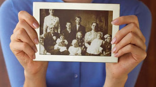 A woman holding an old family photo.