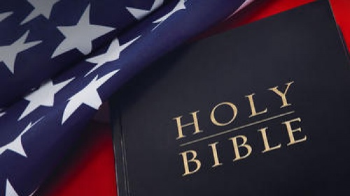 Holy Bible on laying on top of United States flag