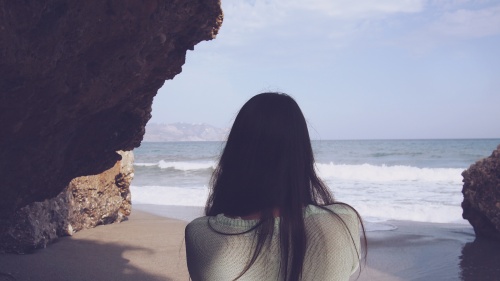 Woman looks at the ocean.