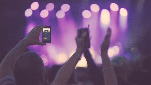 A man recording concert on his smartphone.