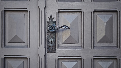 Old door with ornate handle and key hole.