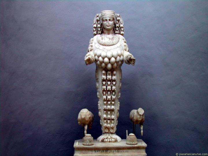 La Artemisa de Éfeso era la diosa de la fertilidad y se le representaba con múltiples pechos, una corona de forma de torres y una especie de nimbo detrás de la cabeza. 