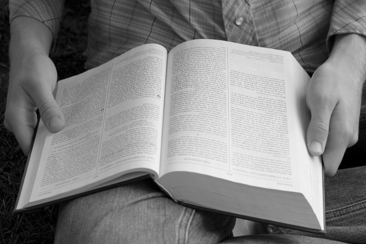 A person holding a Bible on their lap.