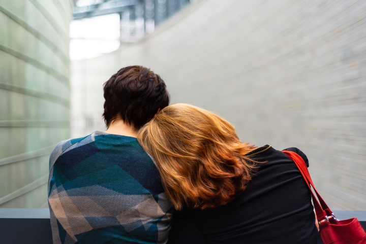 Two friends leaning on each other for support.