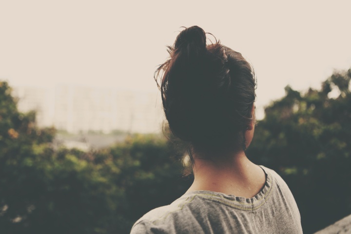 a woman's head, turned towards the landscape with trees