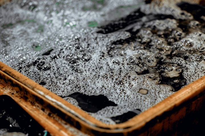 a rusty tub holding dark, bubbly water