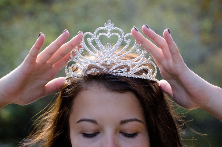 a woman placing a crown on her head