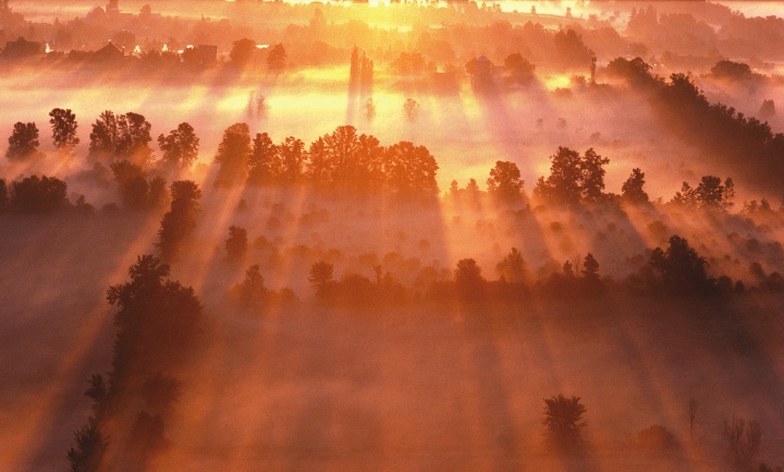 A foggy sunrise over farmlands.