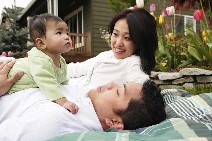 A husband and wife holding their baby.