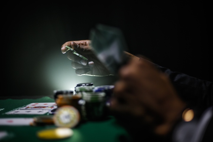 A poker player holding cards and chips.