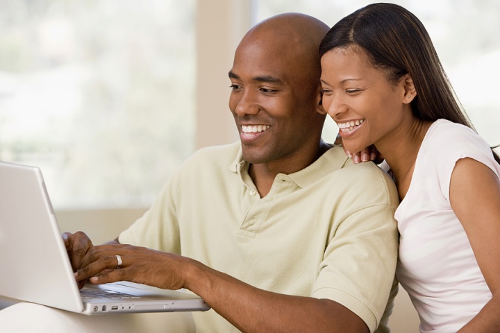 A young couple looking at a laptop computer.