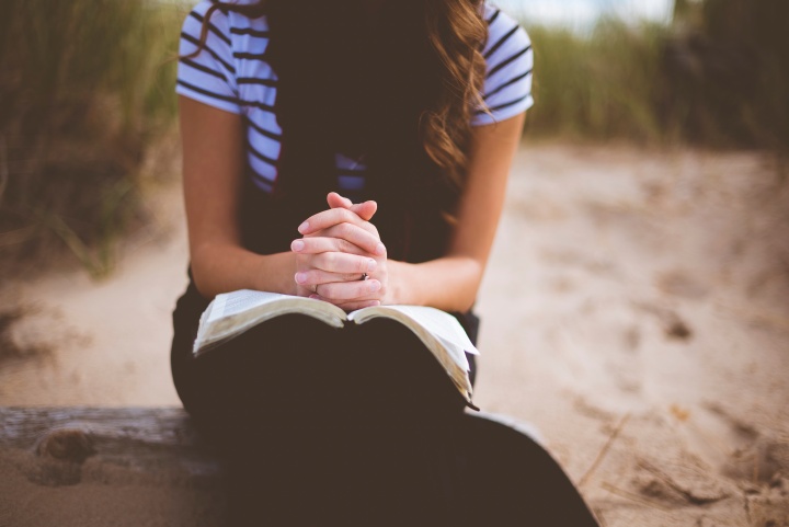 A woman with an open Bible on her lap.