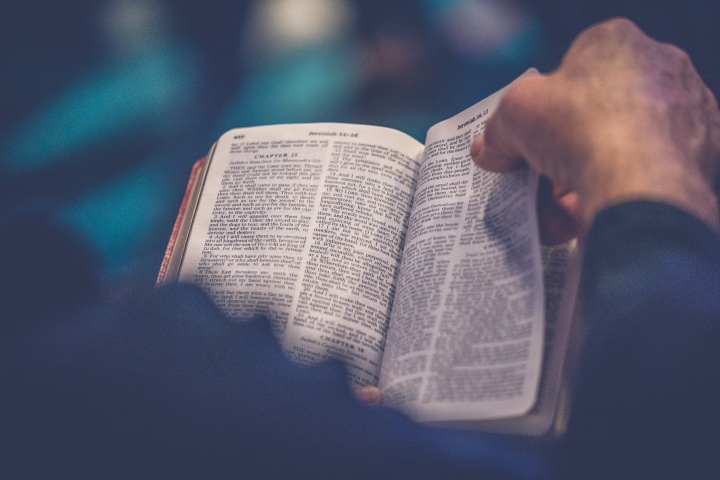 A man holding an open Bible. 