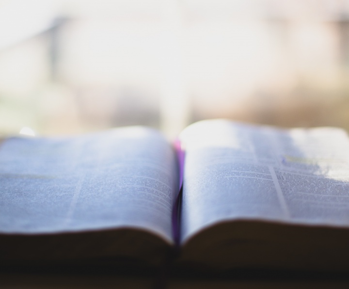 A open Bible in front of a window.