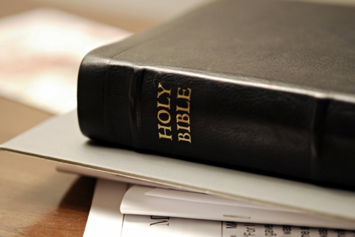 A Bible laying on top of papers.