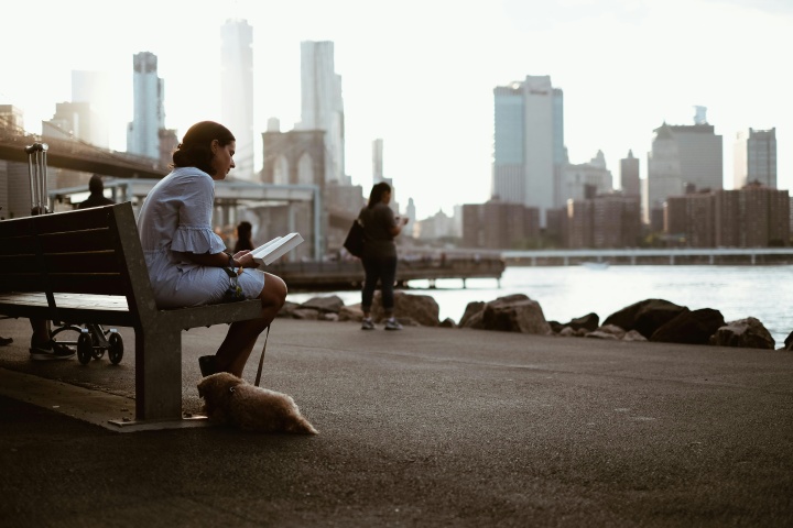 A woman sitting on a park bench reading.