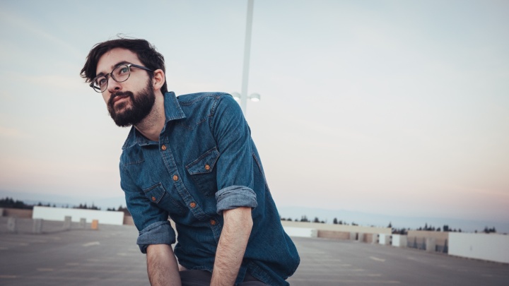 Upclose photo of young man with a beard wearing glasses