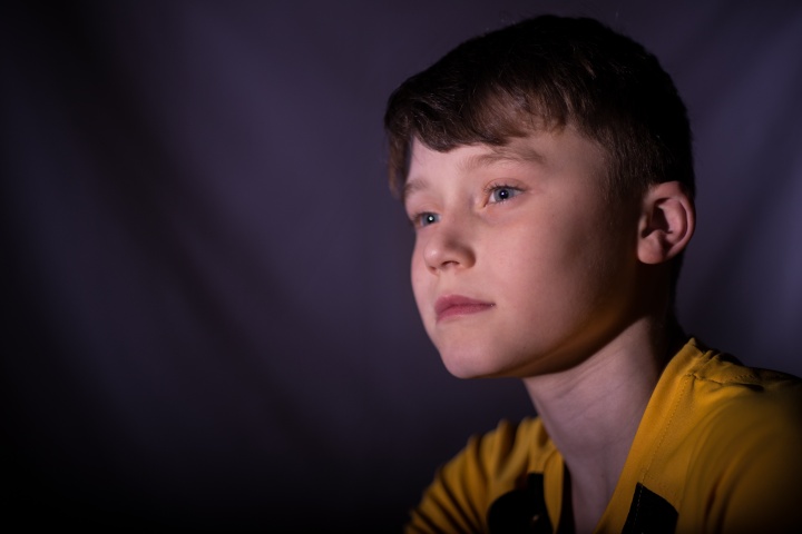 A young boy staring as if thinking about something.