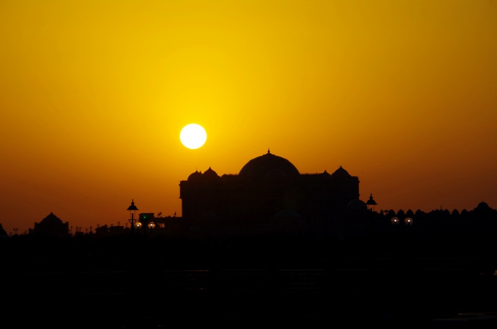 A sunset over a Muslim mosque.