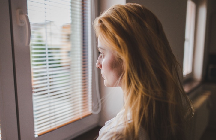 A young woman staring out a window.
