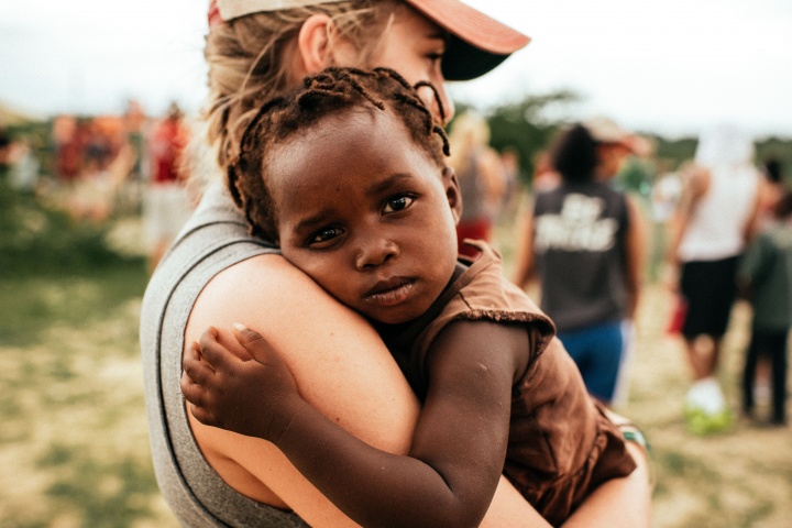 A young woman holding a small child.