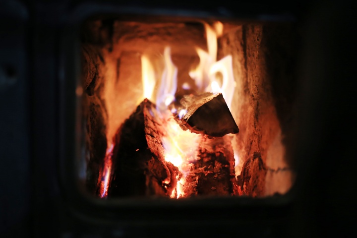 A fire burning inside a wood stove.