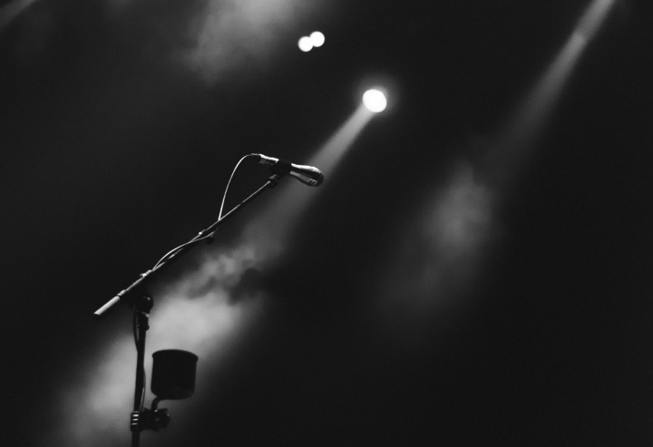 A microphone on a stage lit by a spotlight.