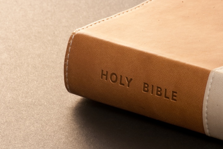 A brown Holy Bible on a table.