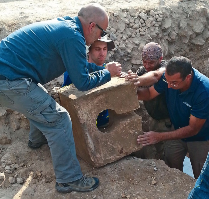 Diggers remove a stone toilet that was used to defile the shrine where the altar was found.