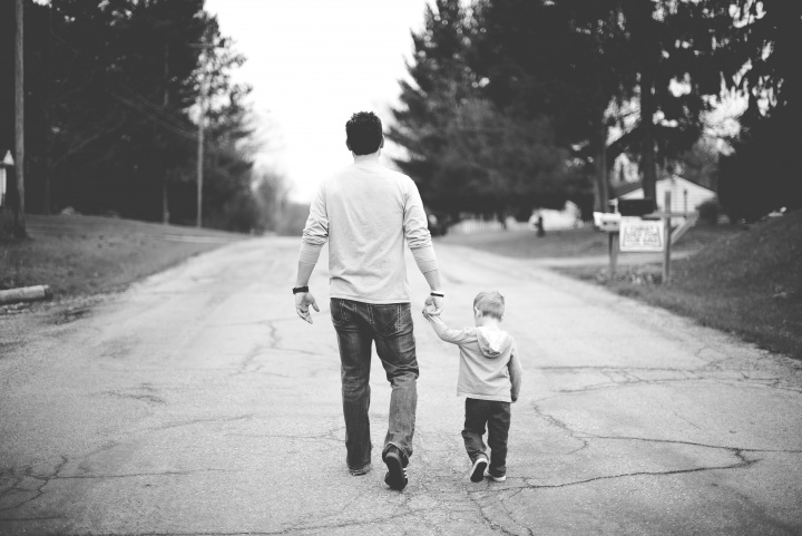 A dad walking with his young child.