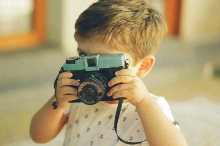 A little boy playing with a camera.