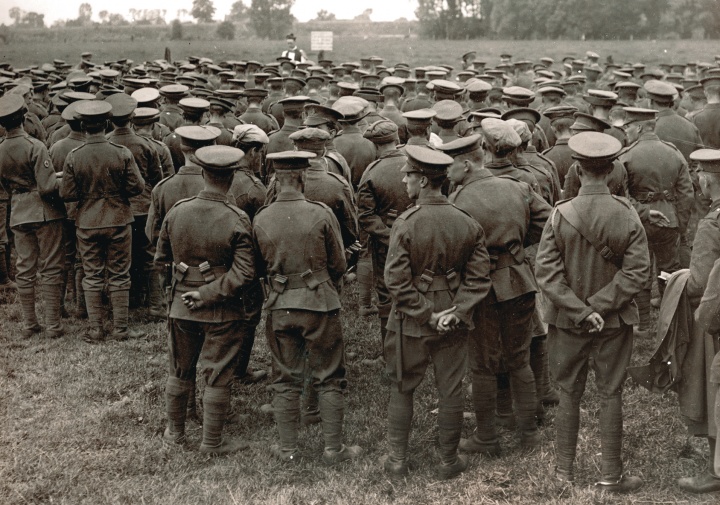 An old WWI photograph showing a church service in the field with soldiers watching a priest.