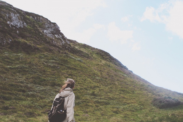 A woman beginning a hike up a steep incline.