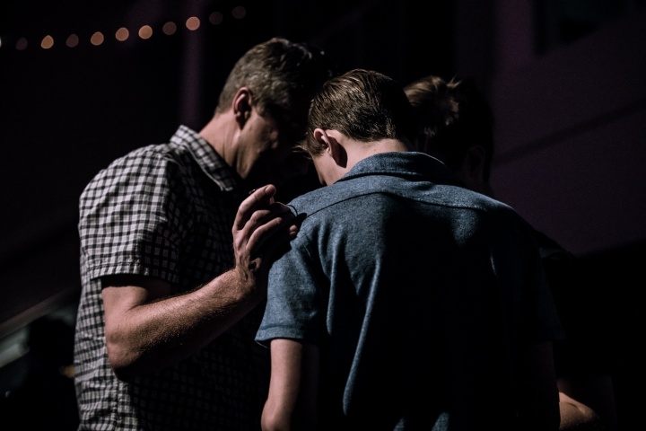 Two men praying together.