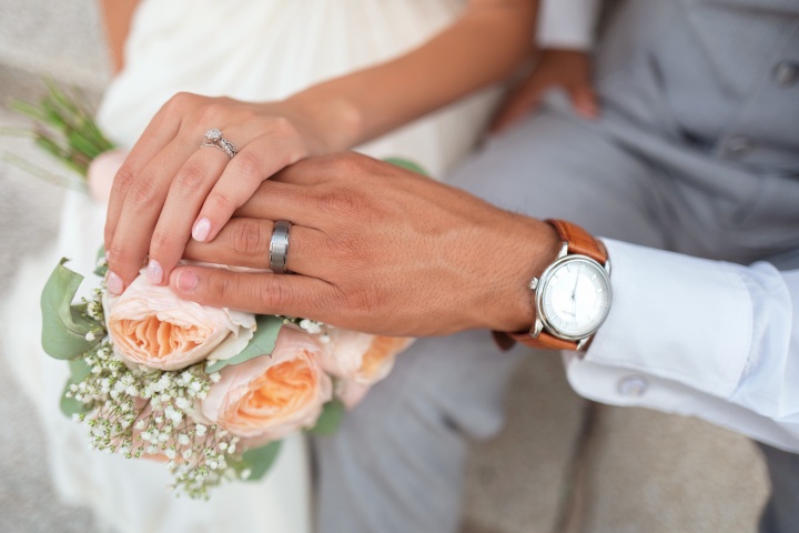 Photo of bride and groom holding hands.