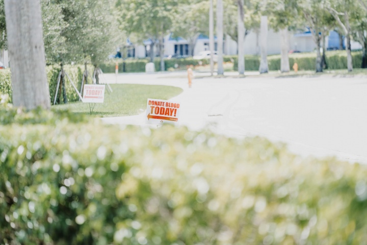 Photo of a sign, pointing to a donation center, saying "Donate Blood Today."