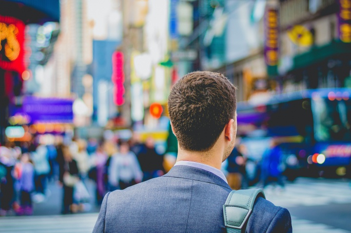 A business man walking in a busy city.