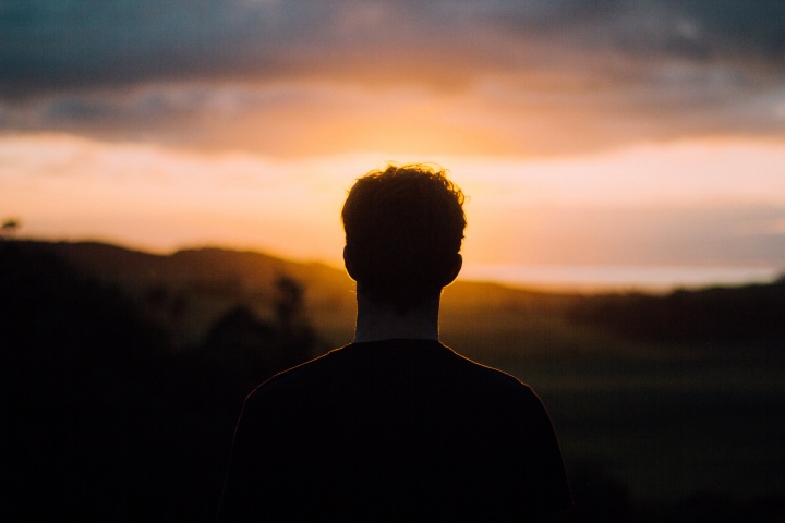 A young man watching the sunset.