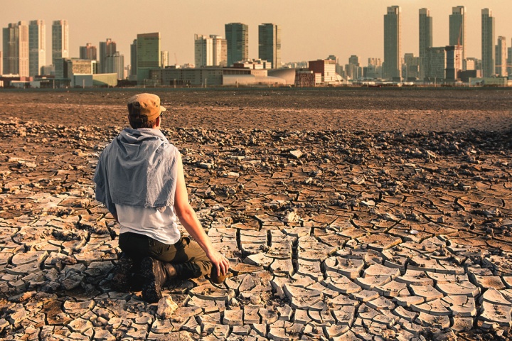 A person sitting on dry barren dirt.