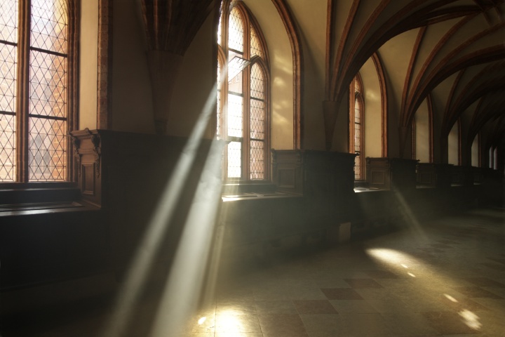 Sun rays shining through the windows of an old church.