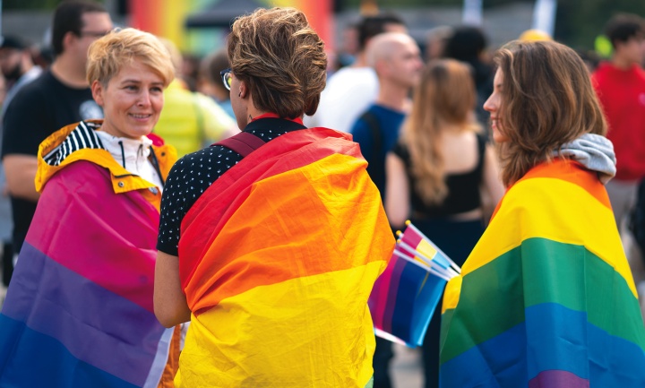People with pride flags covering their shoulders.