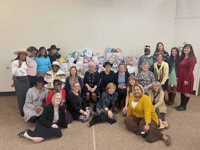 Ladies standing and seated around a table of donations