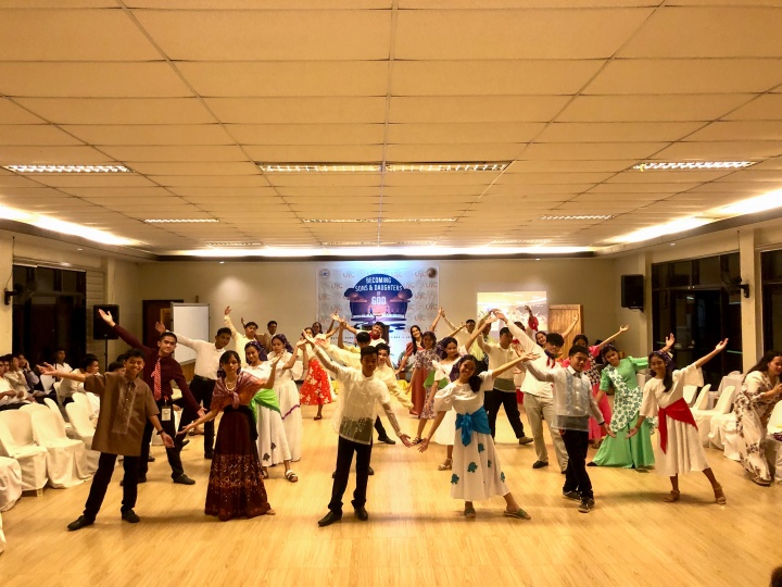 a group of teenagers wearing traditional costumes and dancing