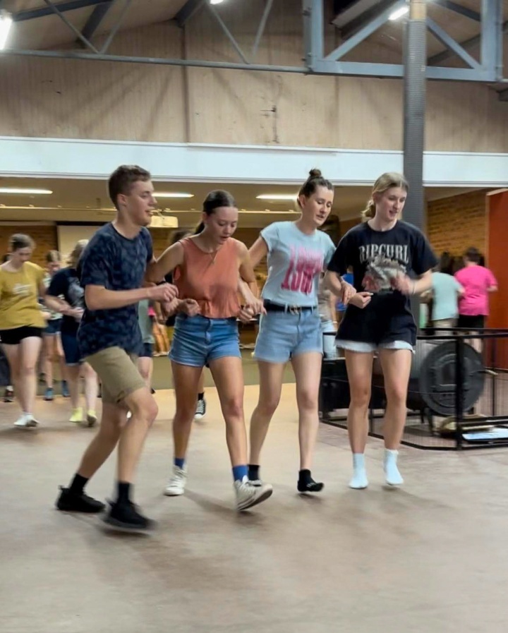 a group of campers arm in arm for a dance