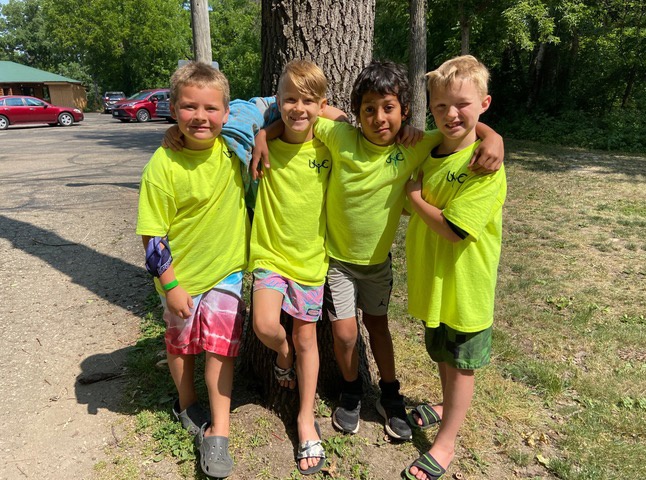 four boys standing outside wearing matching UYC shirts