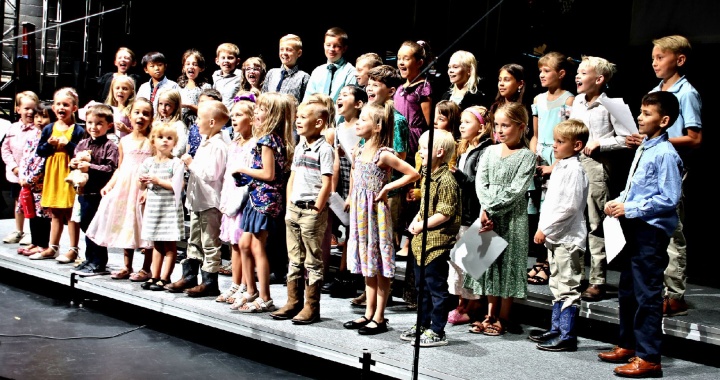 a large children's choir standing on a stage