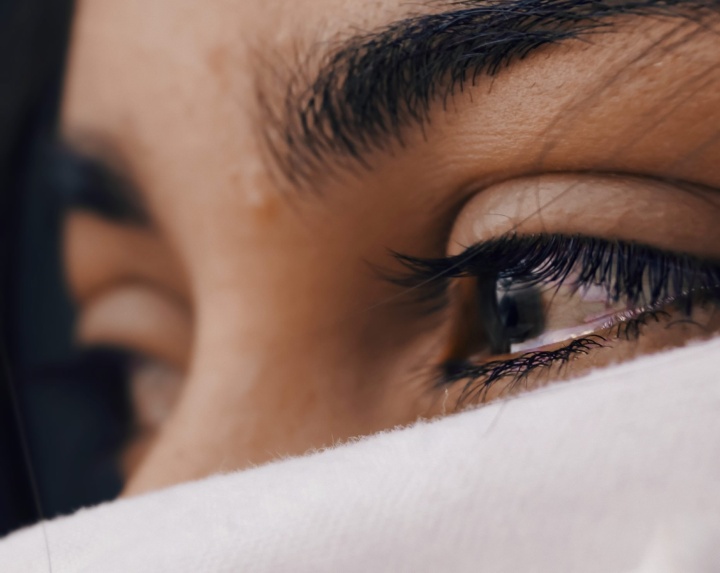 A closeup of a woman's eyes with tears.