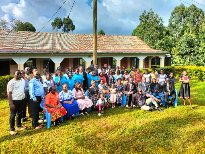 a large group of people standing and seated outdoors