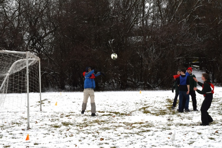a group of teenagers outside playing speedaway in the snow
