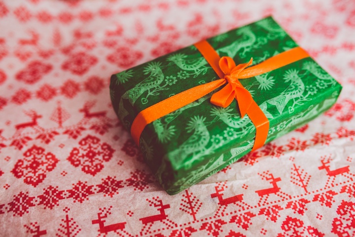 A green present wrapped with red bow.
